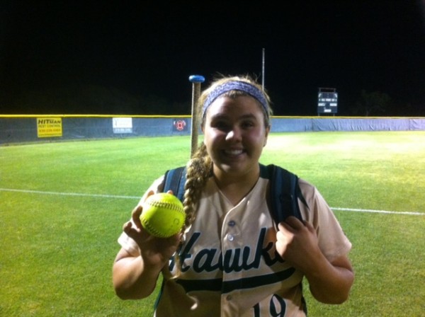 Kelsey Ahrens holding what used to be a round Softball after her walk-off 3-run homer