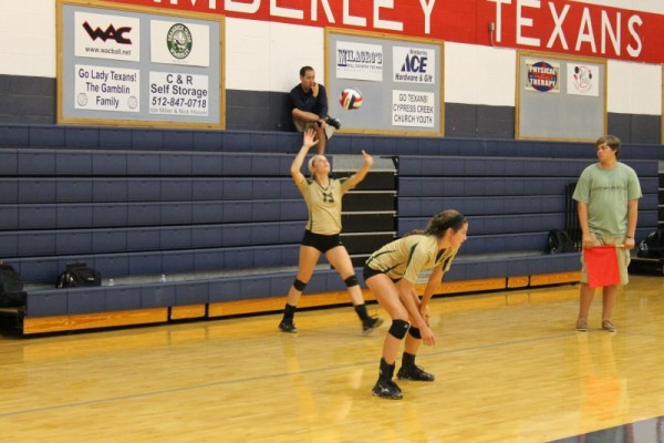 Senior Alexis Robinson in Wimberley last week with her serve as Bailey Drum gets ready 