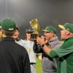 Coach Victor Escamila & Coach Daniel Lancaster hold District Trophy up high after final win over Davenport clinching a first for Canyon Lake.