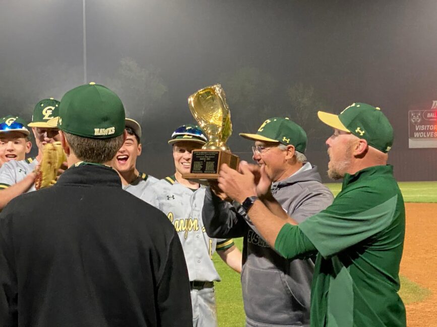Coach Victor Escamila & Coach Daniel Lancaster hold District Trophy up high after final win over Davenport clinching a first for Canyon Lake.